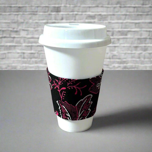 Handmade Cup Sleeve: Ethnic fabric design in black, pink and white floral print. This vibrant and stylish cup sleeve adds a touch of cultural sophistication to your drinkware.