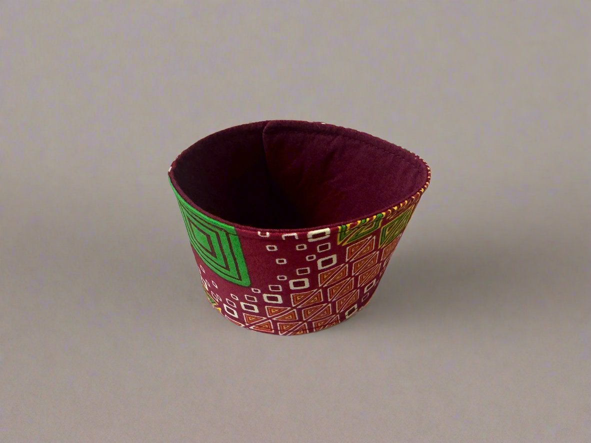 Handmade Cup Sleeve: Ethnic fabric design in red, green, cream, and yellow. This eye-catching and culturally inspired cup sleeve adds vibrant style to your drinkware.