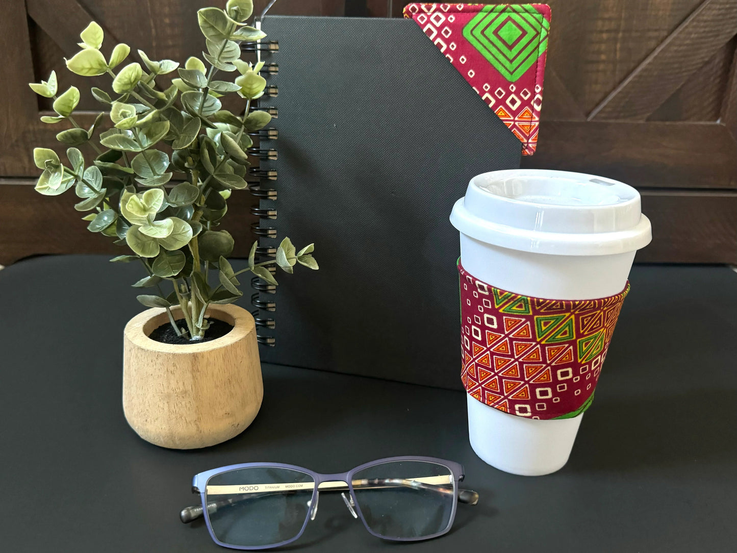 Handmade Cup Sleeve: Ethnic fabric design in red, green, cream, and yellow. This eye-catching and culturally inspired cup sleeve adds vibrant style to your drinkware.