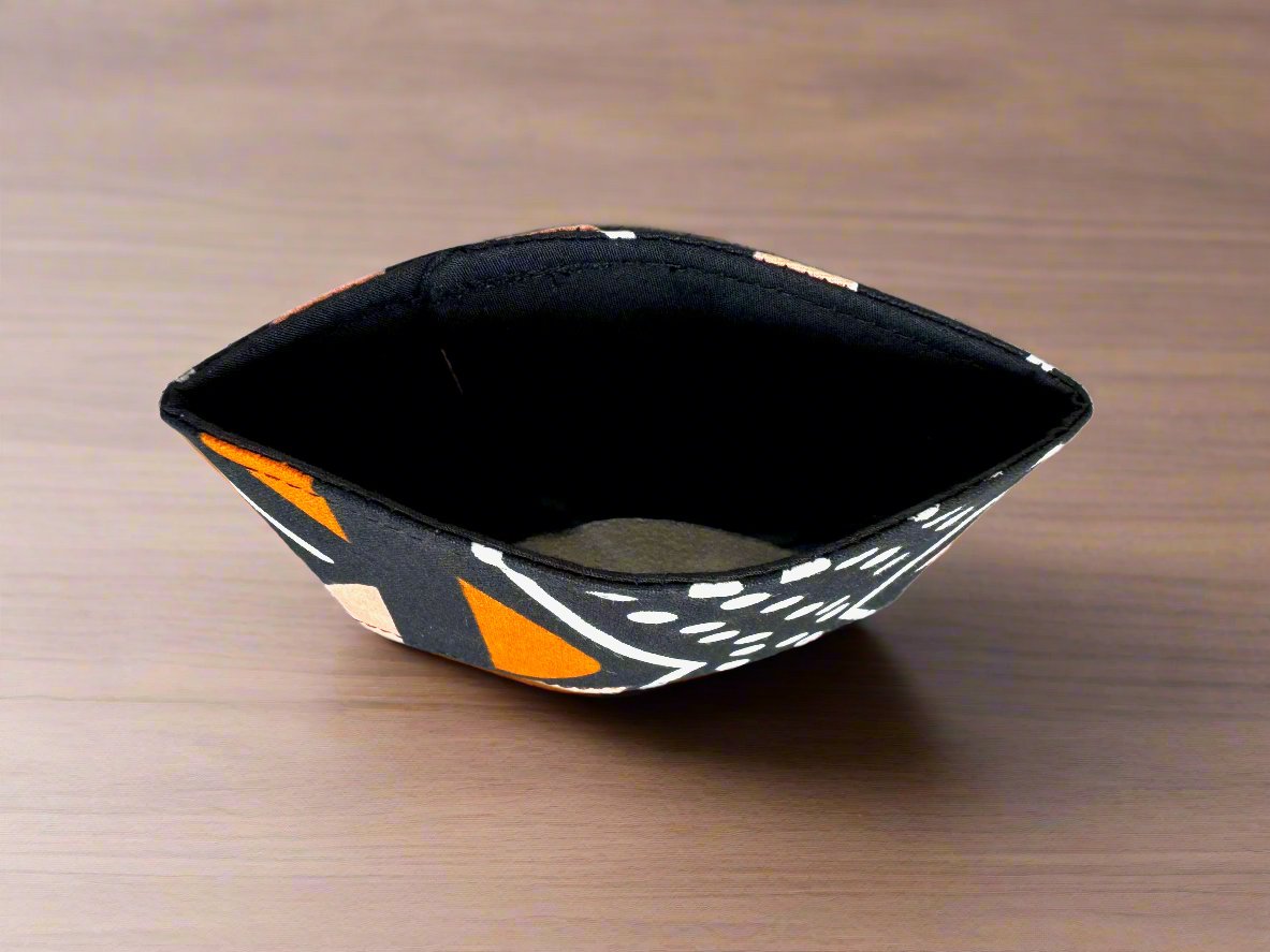 Handmade Cup Sleeve: Ethnic fabric design in black, orange, and white. This vibrant and stylish mud cloth inspiredcup sleeve adds a touch of cultural sophistication to your drinkware.