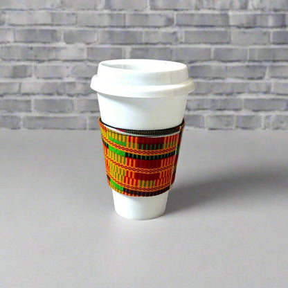 Handmade Cup Sleeve: Ethnic fabric design in Handmade Cup Sleeve: Ethnic fabric design in orange, red, green, black, and yellow. This vibrant and stylish cup sleeve adds a touch of cultural sophistication to your gift giving.