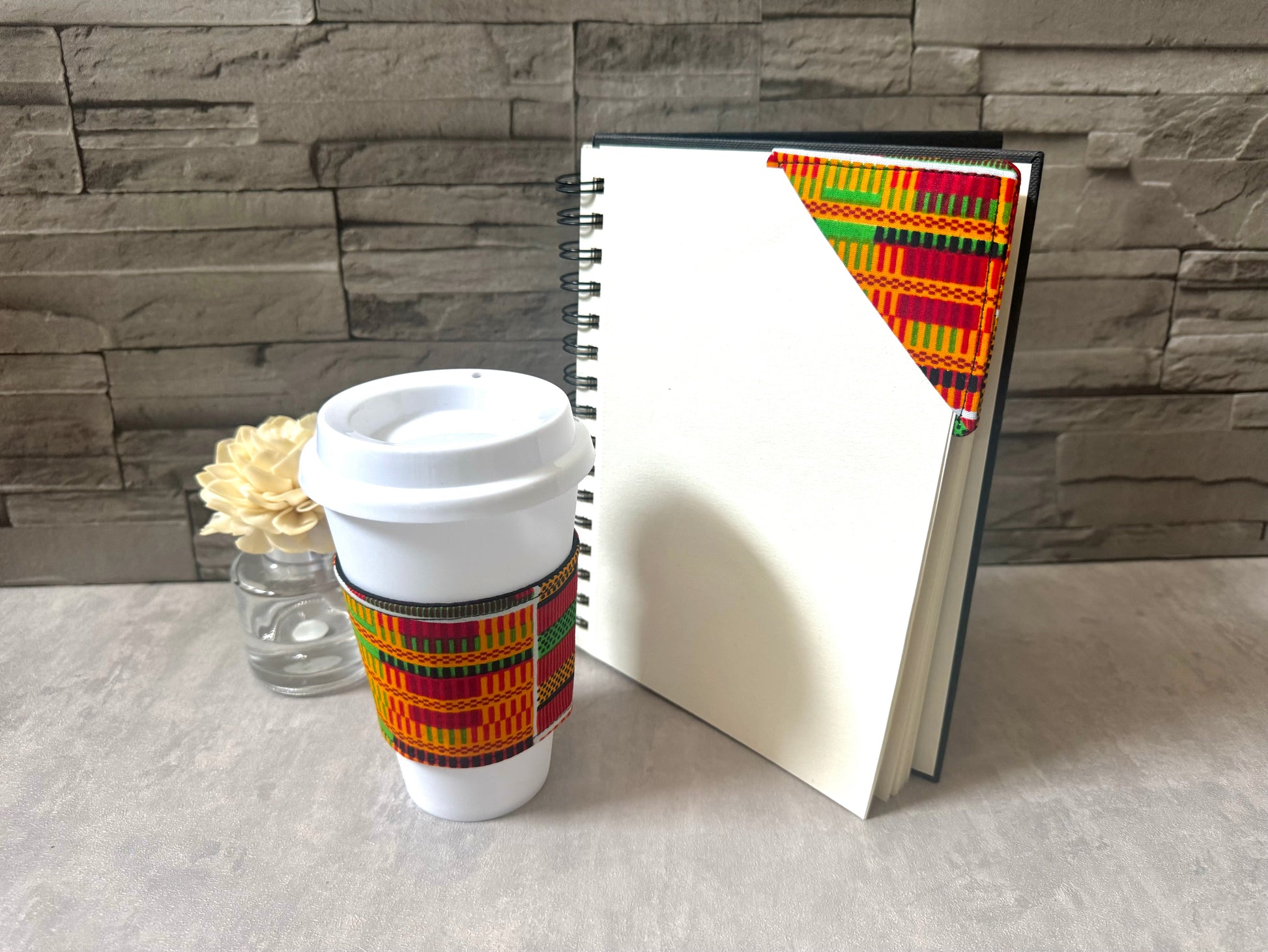 Handmade Cup Sleeve: Ethnic fabric design in Handmade Cup Sleeve: Ethnic fabric design in orange, red, green, black, and yellow. This vibrant and stylish cup sleeve adds a touch of cultural sophistication to your gift giving.